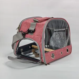 Close-up view of the open side flap showing the wooden perch and metal tray of the bird carrier