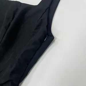 Detail shot showing the side invisible zipper of a black square neck sleeveless dress