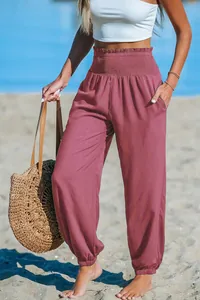 Close-up of women's high waisted smocked joggers in mauve for casual beach wear style