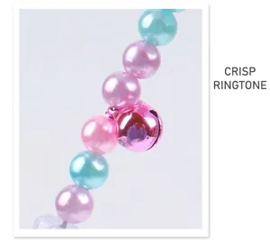 Close-up of colorful pearls and pink metallic bell on pet cat teaser wand toy detail