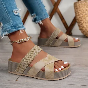 Primo piano di sandali platform beige da donna con cinturini intrecciati incrociati