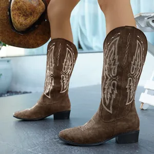 Detailansicht von braunen Wildleder-Cowboyboots mit weißen Stickereien und Blockabsatz.