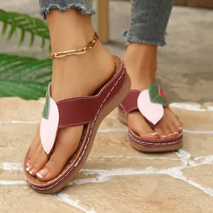 Detalle de chanclas de cuña elegantes con detalles de hojas en contraste