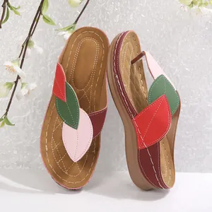 Vista detallada del diseño de hojas coloridas en sandalias de cuña para mujer