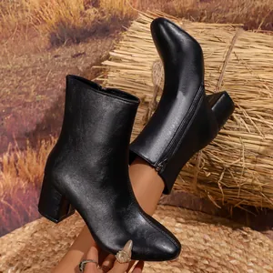 Black glossy leather pointed-toe ankle boots with side zipper and block heel design.