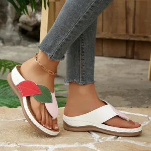 Vista detallada de chanclas con cuña para mujer con diseño de patchwork de hojas.