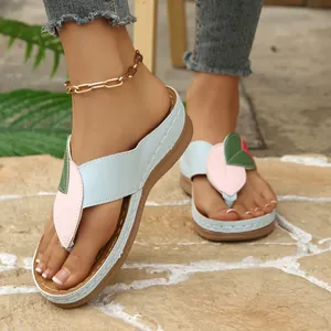 Primer plano de chanclas con cuña para mujer con parches coloridos en forma de hoja.
