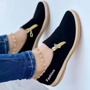 Gros plan de mocassins noirs pour femmes avec zip doré et semelle plateforme en corde