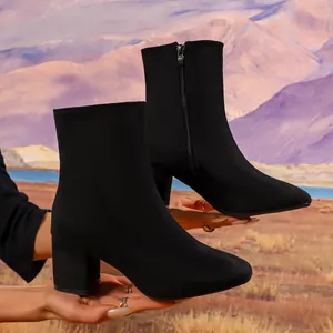 Elegant black faux suede block heel ankle boots with side zipper in mountain setting