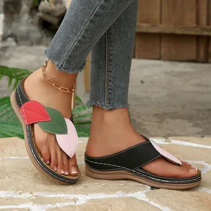 Primer plano de sandalias de cuña para mujer con diseño de hojas coloridas al aire libre