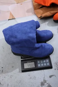 Detailed close-up showing blue suede boots weighing exactly 498 grams on a digital scale
