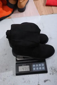 Detail showing the weight of black slouchy western knight boots on a digital scale