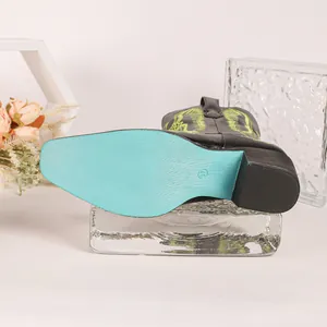 Détail de la semelle bleu turquoise d'une botte de cowboy noire brodée