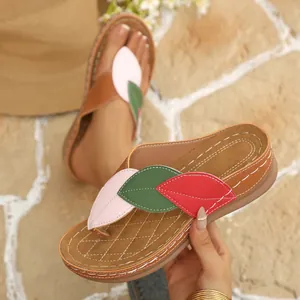Vista detallada de chanclas de cuña para mujer con parches decorativos de hojas de colores