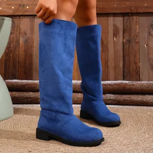Close-up of vibrant blue suede slouchy knee-high boots showing fabric texture and fit
