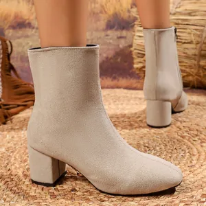 Detailed side view of elegant beige suede chunky heel ankle boots for women's fashion