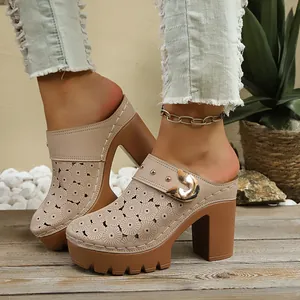Detailed view of high-heeled mules with intricate floral cutout pattern and chunky heel