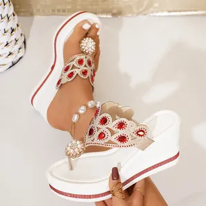 Close-up of white wedge sandals with vintage red rhinestones and pearl embellishments