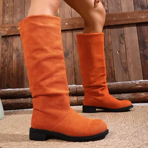 Close-up of vibrant orange slouchy western cowboy boots for women with low block heel