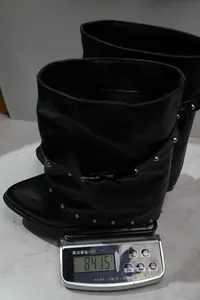 Detailaufnahme des Gewichts eines schwarzen, spitzen Slouchy-Stiefels mit Nieten