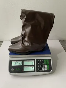 Detailaufnahme brauner Faltenstiefel, die auf einer elektronischen Waage gewogen werden.