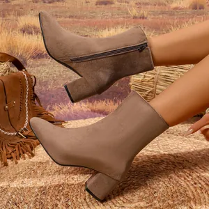Close-up of brown suede ankle boots featuring a pointed toe, block heel, and side zipper