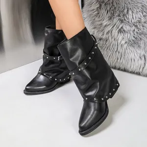 Nahaufnahme schwarzer Slouch-Stiefel mit silbernen Nieten und spitzer Zehenpartie.