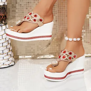 Detail of ethnic platform wedge sandals with red rhinestones and pearl toe decor