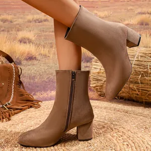 Stylish brown suede ankle boots featuring a chunky block heel and side zipper detail.