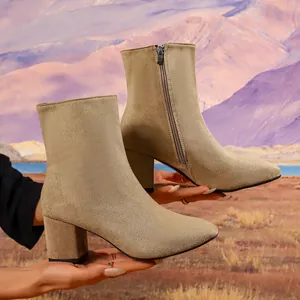 Side view of elegant beige suede ankle boots with square heel and side zipper detail