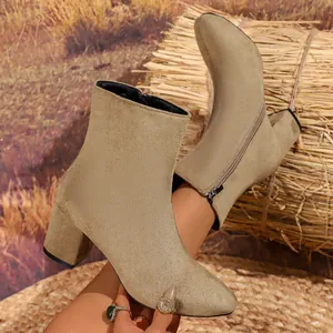 Close-up detail of khaki suede women's ankle boots with side zipper and block heel