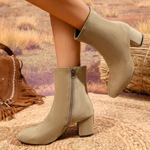Macro detail of stylish khaki faux suede ankle boots with side zipper and block heel