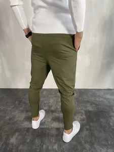 Vista posteriore di pantaloni sportivi slim fit verde oliva da uomo con polsini a zip.
