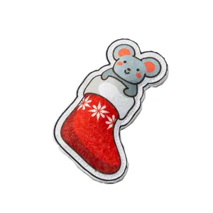 Nahaufnahme eines Katzen-Weihnachtsspielzeugs aus Filz mit Maus in einem roten Strumpf