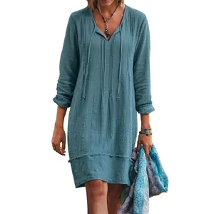 Detailed view of a blue V-neck midi dress featuring textured fabric and a tie neck