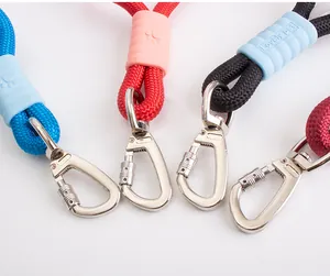 Close-up of durable metal carabiners and silicone sleeves on colorful pet leashes.