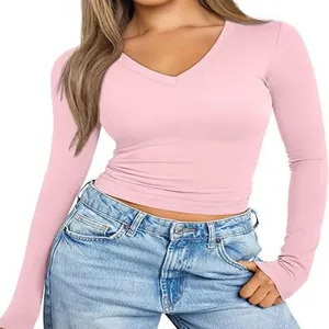 Detail view of a pink women's V-neck long sleeve slim fit t-shirt styled with jeans