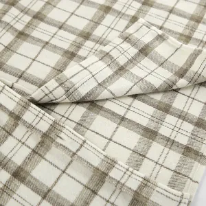 Close-up detail of retro beige and brown plaid fabric texture for casual shirt.