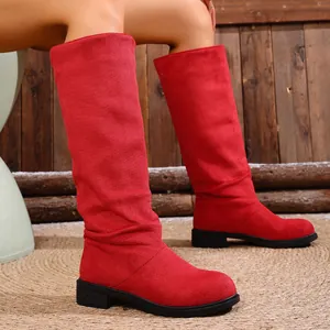 Detailed view of red suede-like slouchy knight boots featuring a flat black heel