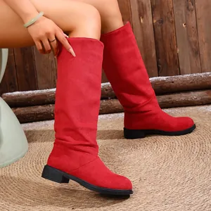 Chic women's red slouchy mid-calf boots shown in a cozy rustic indoor setting
