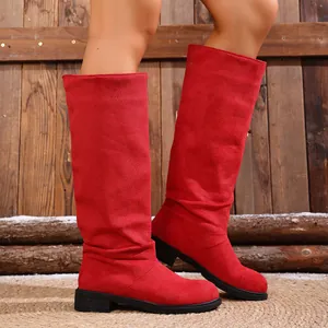 Detailed shot of vibrant red slouchy mid-calf western boots with rustic wooden backdrop