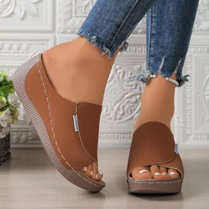 Detailed view of brown platform wedge sandals featuring peep-toe and contrast stitching