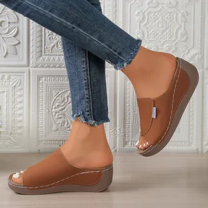 Detailed side view of women's brown thick sole wedge sandals with white stitching