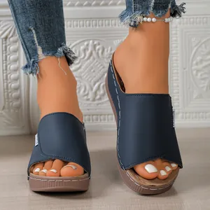 Detail view of navy blue platform wedge slides with peep toe and contrast stitching