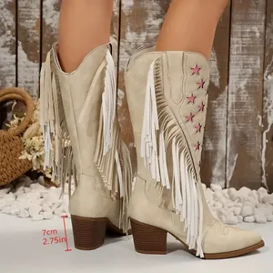 Macrodetail van beige western cowboylaarzen met witte franjes en een blokhak van 7 cm