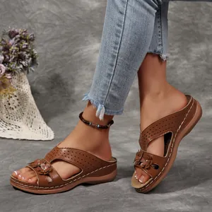 Detailansicht der braunen Retro-Keilsandalen mit Blumen, Hohlmuster und Peep-Toe-Design