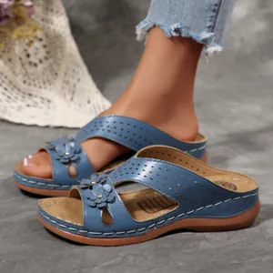 Detailansicht blauer Keilsandaletten mit Blumenverzierung am Fuß für den Strand.