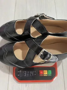 Dettaglio scarpe Mary Jane nere con cinturino a croce, peso 311,4g sulla bilancia