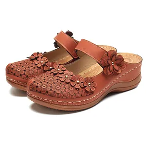 Detailansicht der braunen Vintage-Keilsandalen mit Blumenmuster und dekorativem Lochmuster