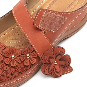 Makroansicht der Vintage-Blumendekorationen und des Klettverschlusses an Ledersandalen.